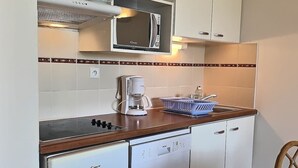 A compact kitchen with a microwave, coffee maker, and dishwasher.