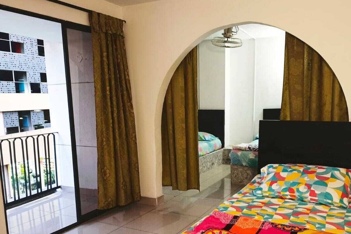 Une chambre d’hôtel avec un lit, un balcon et une vue sur un immeuble doté de nombreuses fenêtres.