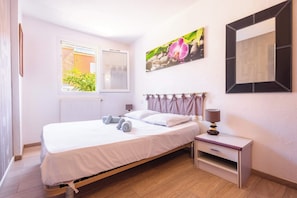 Una camera da letto con un letto, un comodino e una finestra con vista.