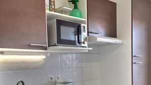 Una cocina moderna con electrodomésticos de acero inoxidable, un lavamanos doble y armarios de color marrón.