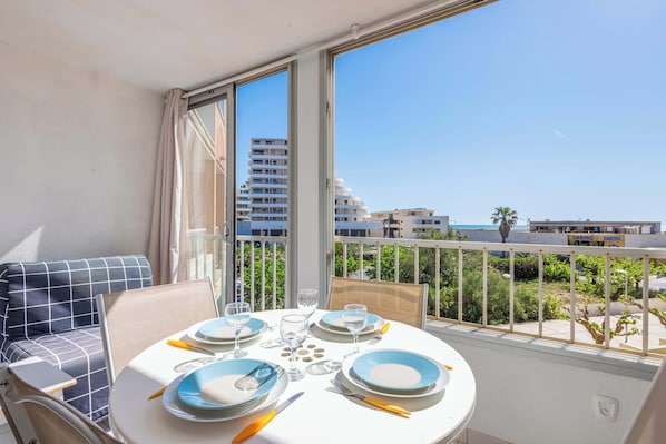 Ein Balkon mit Esstisch für zwei Personen, mit Blick auf eine Stadtlandschaft und ein Kasino.