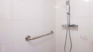 A bathroom with white tiles, a handrail, and a showerhead. - Valras Apartment with Sea View (Valras-Plage)
