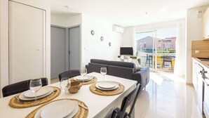 A dining area with a table set for four, a sofa, and a kitchen area visible.
