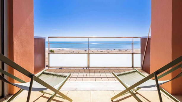 Un balcon avec vue sur la plage et l’océan.