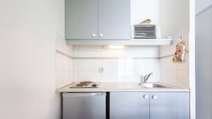 Una cocina compacta equipada con lavavajillas, microondas y un lavamanos.
