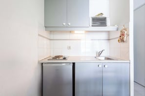 A compact kitchen with a built-in dishwasher, a microwave, and a sink.