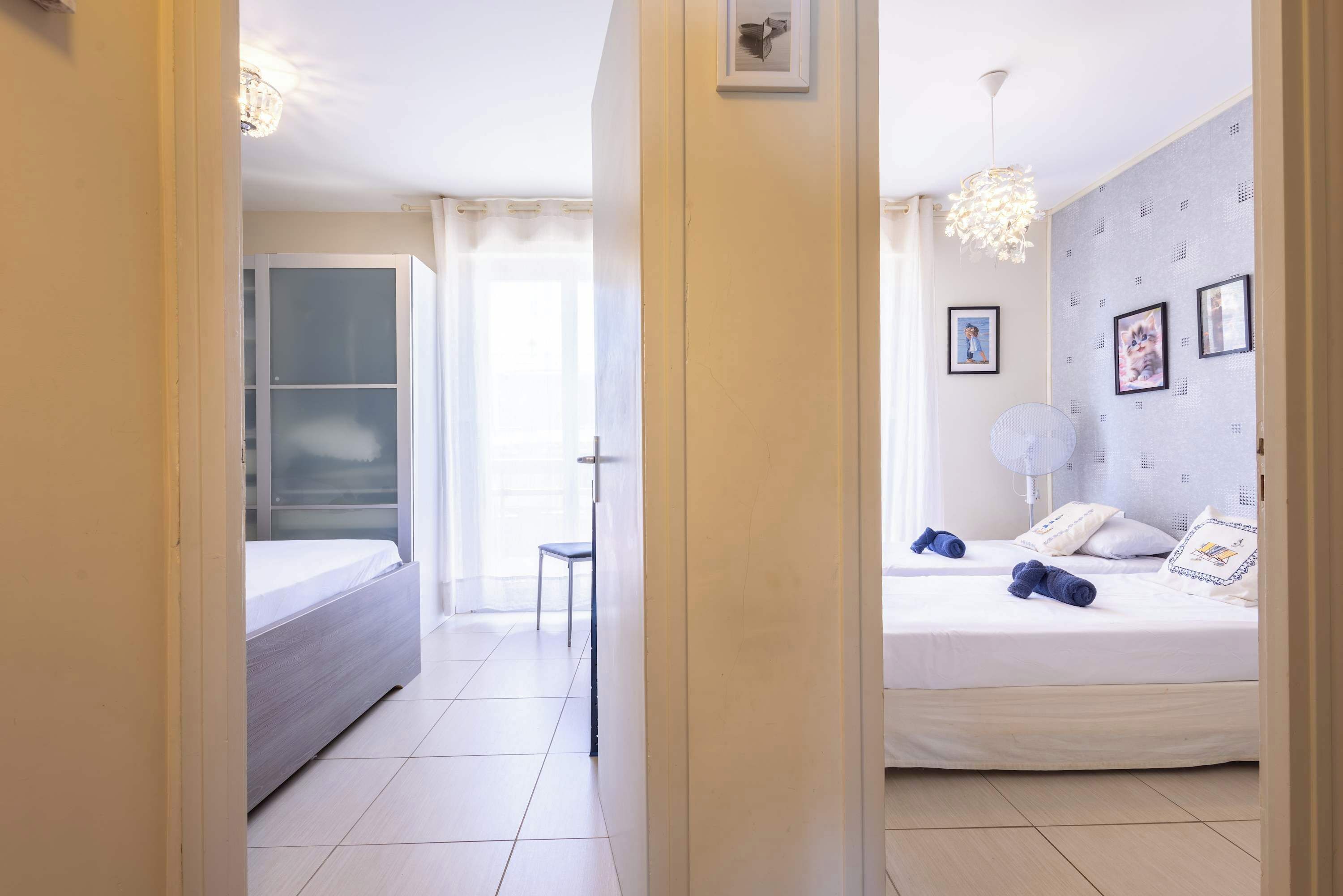 Ein Hotelzimmer mit einem Bett, einem Sessel, einem Nachttisch und einer Deckenleuchte.