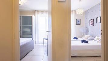 Ein Hotelzimmer mit einem Bett, einem Sessel, einem Nachttisch und einer Deckenleuchte.
