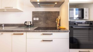 A modern kitchen with a stainless steel range hood, a built-in microwave, and a Bosch oven. - Villa Bianca - Air-conditioned pavilion 500m from (Sérignan)