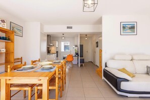 Un interior moderno con comedor, cocina y sofá.