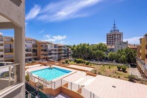 A residential building with a swimming pool, balconies, and a clear view of the surrounding area. - Agde’Loc – Le Nid du Port (Agde)
