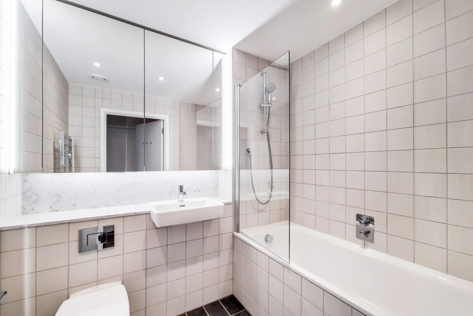 A modern bathroom with a white sink, a shower, and a bathtub.