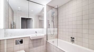 A modern bathroom with a white sink, a shower, and a bathtub.