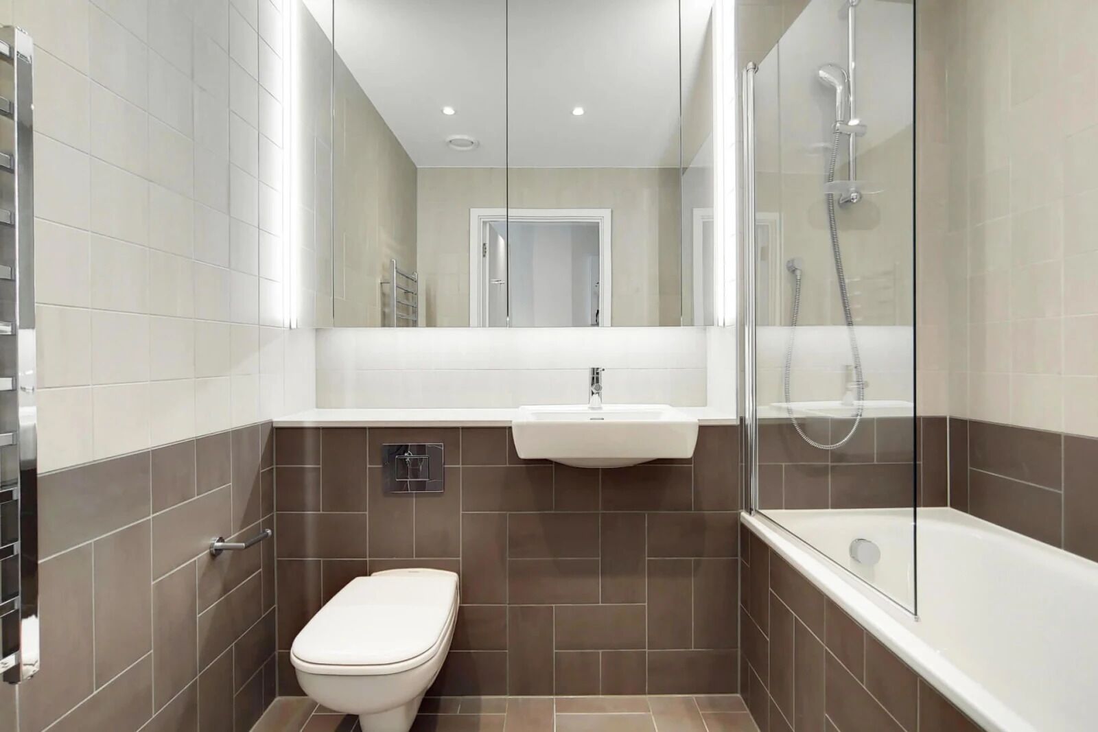 A compact bathroom with a toilet, sink, and shower.