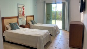 A hotel room with two beds, a nightstand, a lamp, a painting, and a view through the open window. - Paradise in Marbella, Sea Sun Golf & more Groudfloor apartment with pool access (Marbella benahavis)
