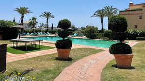 A pool area with lounge chairs, a clear sky, and well-maintained landscaping. - Paradise in Marbella, Sea Sun Golf & more Groudfloor apartment with pool access (Marbella benahavis)