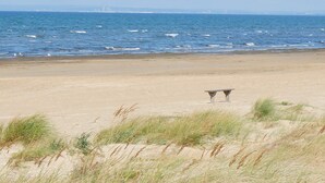 A beach with two stone benches facing the ocean. - 4 Star Holiday Home in Mellbystrand (Mellbystrand)
