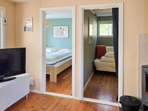 A room with a bed, a television, and a fireplace. - 4 Star Holiday Home in Mellbystrand (Mellbystrand)