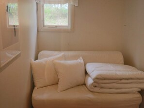 A single bed with white bedding in a room with a window. - 4 Star Holiday Home in Mellbystrand (Mellbystrand)