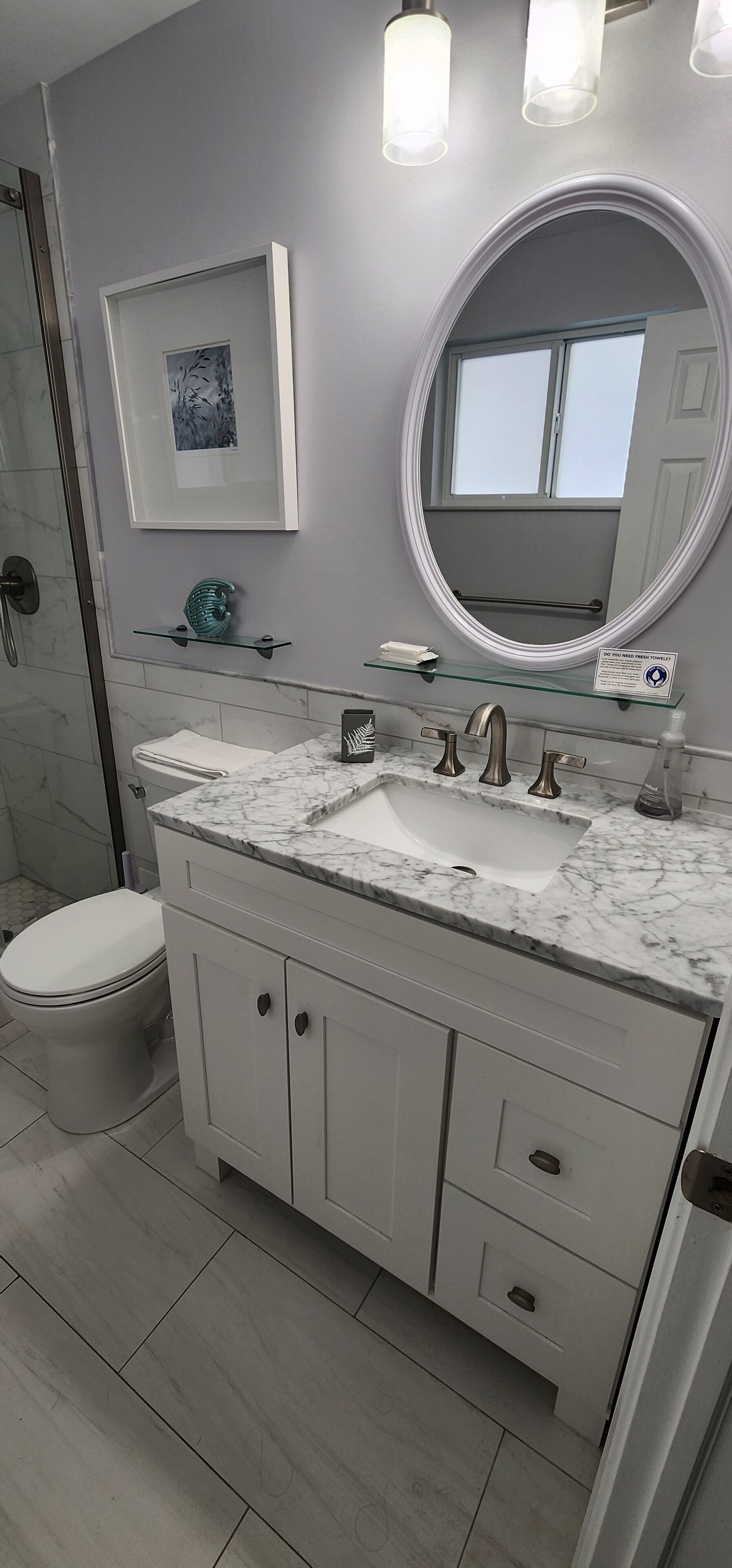 Un bagno con un mobile lavabo bianco, un lavandino, uno specchio e un water.