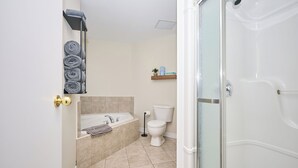 A bathroom with a bathtub, toilet, and shower.