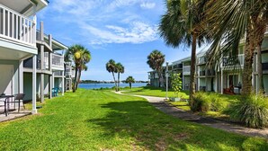 Ein Strandhotel mit Rasenfläche, Palmen und Meerblick.