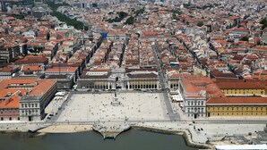 An aerial view of a city with a large open square, historic buildings, and a waterfront. - Downtown River Side by Homing (Lisbon)