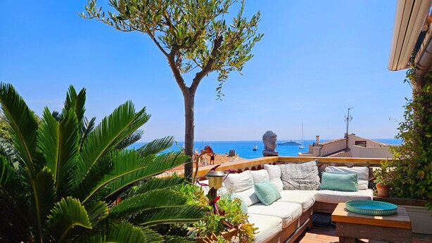 A terrace with a sofa and cushions, potted plants, and a view of the sea and boats. - Le Phare Azur - T3 avec Vue Mer (Antibes)