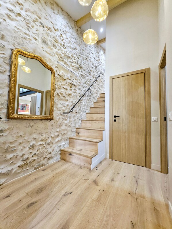 A staircase with a stone wall, a wooden door, and pendant lights. - Le Dotec Méditerranéen - Triplex dans le Vieil Antibes (Antibes)