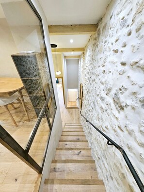 A staircase with a stone wall on one side and a glass partition on the other. - Le Dotec Méditerranéen - Triplex dans le Vieil Antibes (Antibes)