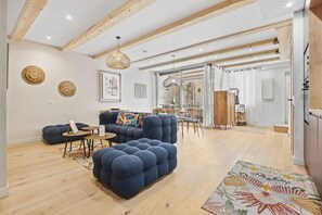 Un salon moderne avec un canapé bleu, une table basse ronde et un tapis à motifs.