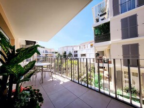 A balcony with a table and chairs, surrounded by potted plants. - Le Marend 4 - T3 avec Terrasse (Antibes)