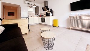 A modern apartment with a kitchen, dining area, and living room. - Le Thuret Fleuri - T3 avec Terrasse (Antibes)