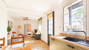 A modern kitchen with wooden countertops, a built-in sink, and a window with a view of trees. - El Capoll - Climatisé, vue montagne (Joch)