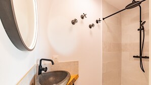 A bathroom with a stone sink, a mirror, and a shower area. - El Capoll - Climatisé, vue montagne (Joch)