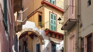 A staircase leading up to a building with a blue chair at the bottom. - Giuliana and Nino's Nest. (Carloforte)