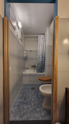 Ein Badezimmer mit Dusche, Toilette und Waschbecken.