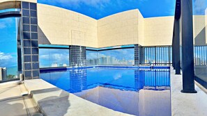 A modern building with a pool and a city view. - Vacanze - Barão de Mauá (Maceio)