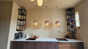 A modern kitchen with a central island, pendant lights, and built-in shelves. - 4BR in oldtown, just steps from opera, Munch, beaches, cafes, shops & local eats (Oslo)