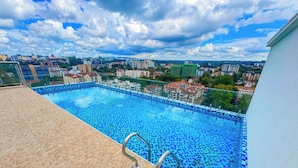 A rooftop pool with a clear view of the cityscape in the background.
