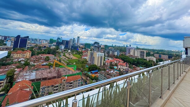 A cityscape with modern buildings, a construction site, and a clear sky.