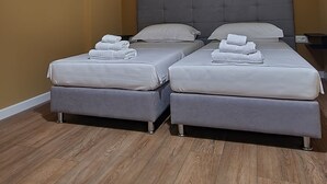 Ein Zimmer mit zwei Betten, einer Deckenleuchte und einer Klimaanlage.