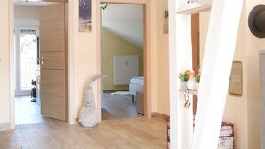 A hallway with a wooden door, a white lamp, and a radiator. - Apartment 'Kirschblüte' (Achern)