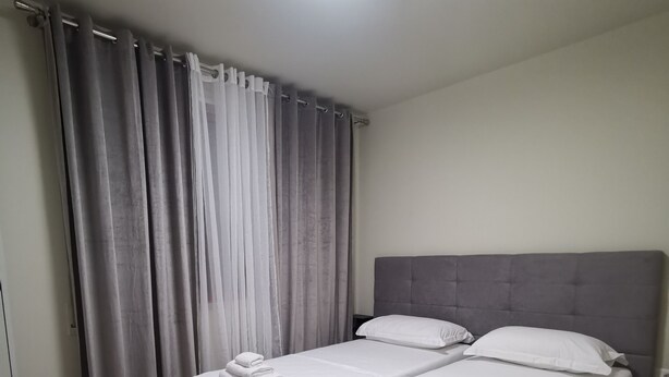 A room with a bed, curtains, and a wooden floor. - Central/2 Bedrooms/KingBed/Balcony/FullKitchen (Durazzo)