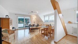 Un amplio loft con comedor, sofá y vistas al exterior.