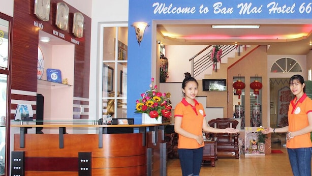 A reception area with a blue sign reading "Welcome to Ban Mai Hotel 66," a reception desk, a large potted plant, and a statue. - Ban Mai Hotel 66 (Phu Thuy)