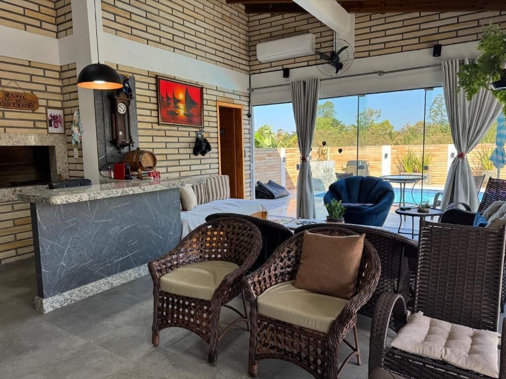 A cozy lounge area with wicker furniture, a fireplace, and a view of the outdoors.