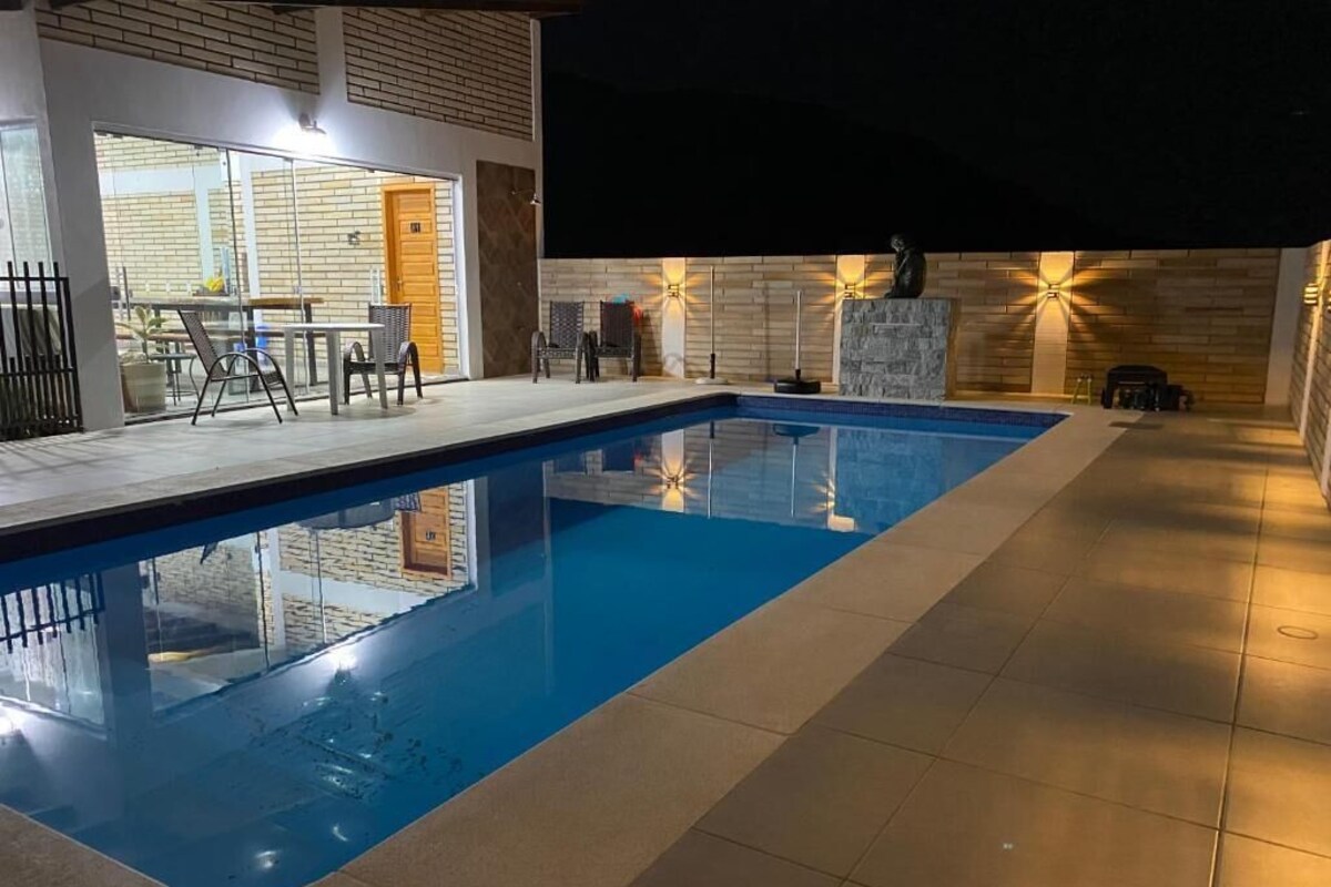 A modern indoor swimming pool with clear water, surrounded by a tiled floor and a brick wall.
