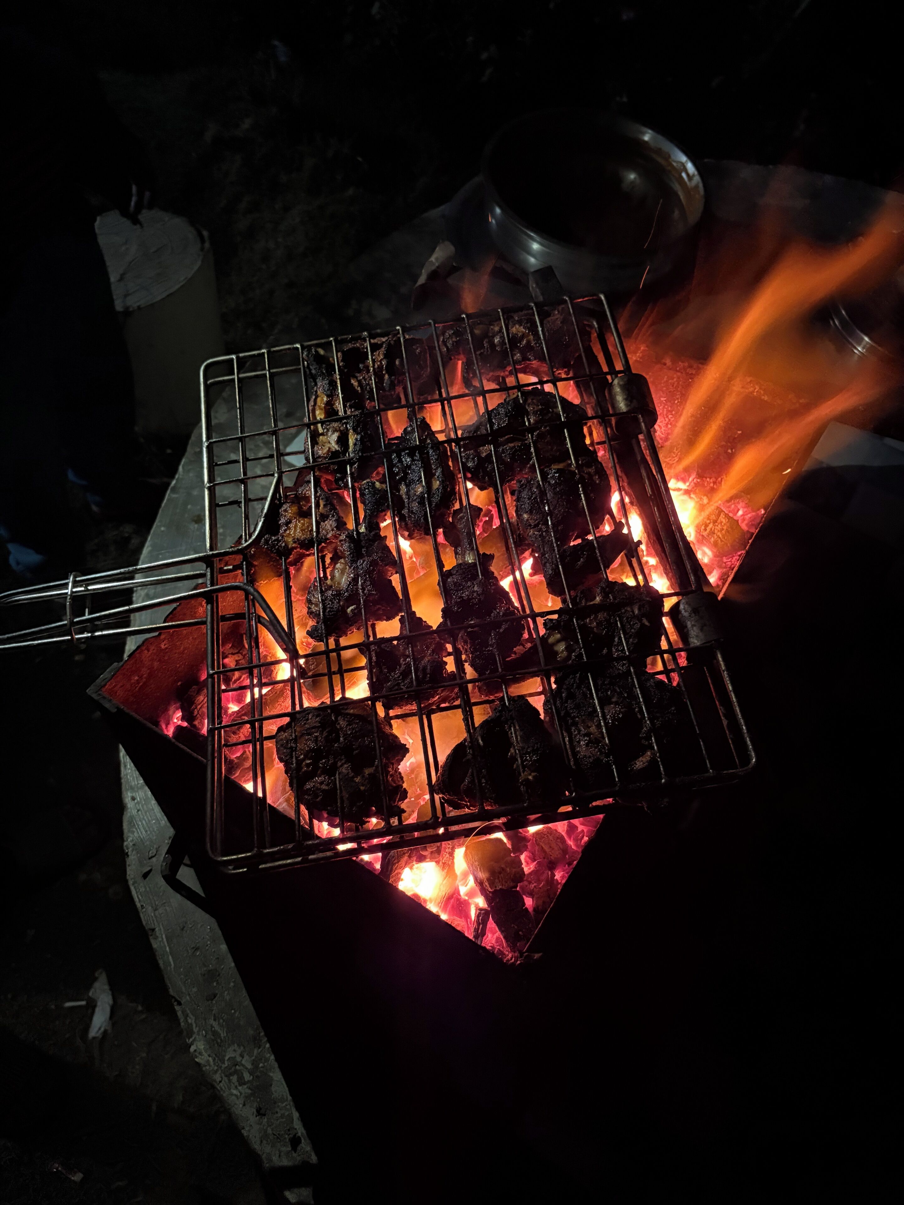 A grill with meat being cooked over an open flame.