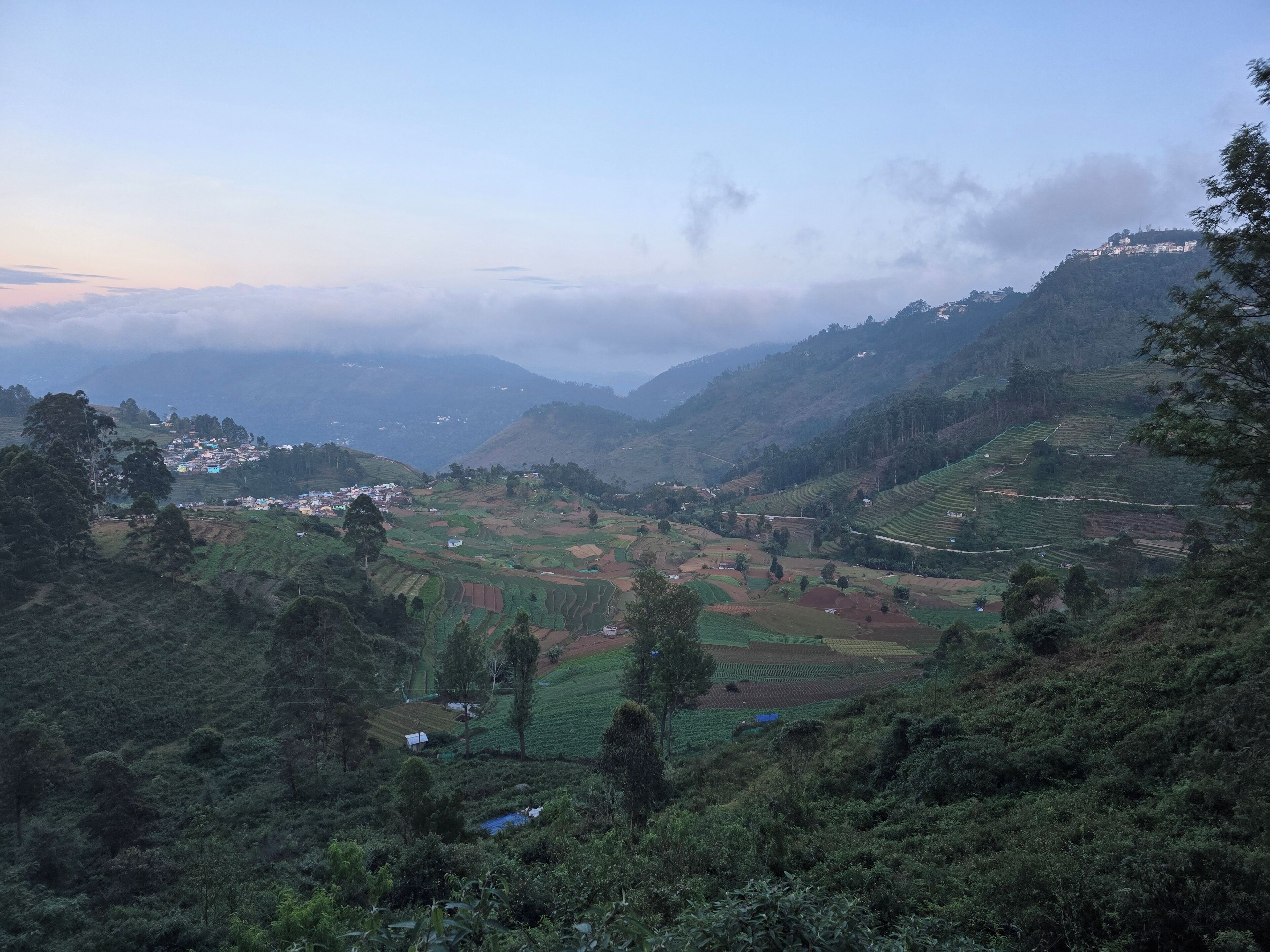 A mountainous landscape with terraced fields and a small settlement.